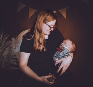 A gentle family moment captured in moody lighting with decorative bunting overhead.