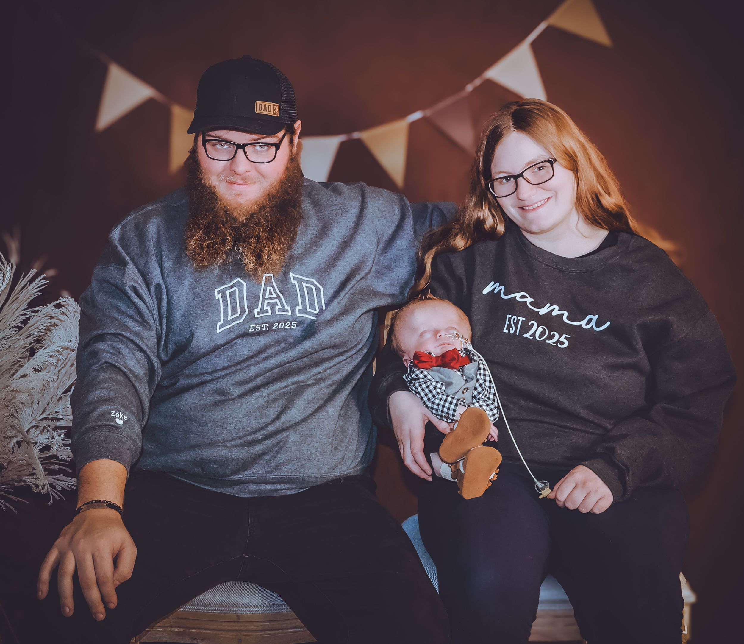 Casual family photo session with matching outfits and festive banner decorations.
