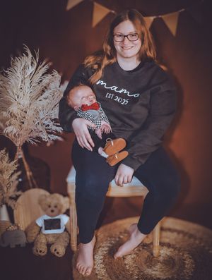 Intimate family portrait session with decorative pampas grass and bunting in dark setting.