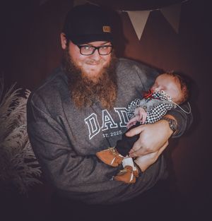 Tender family moments photographed in dim lighting with casual clothing and accessories.