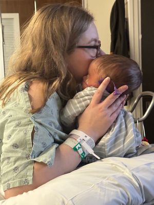 A tender moment in a hospital room showing affection between parent and infant.