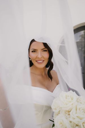 Elegant bridal bouquet of white roses with flowing veil.