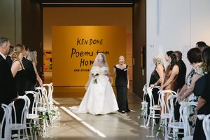 Wedding ceremony setup with white chairs in modern venue.