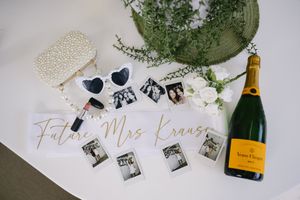 A wedding detail collage featuring champagne bottles, photo prints, and decorative elements on a white surface.