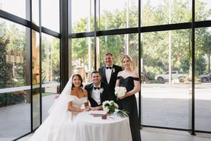 Light-filled modern event space with glass walls and outdoor views during a wedding ceremony.