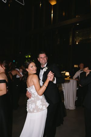 Elegant couple dancing together at a dimly lit wedding reception venue.
