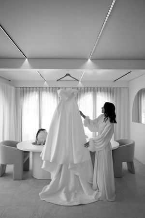 Modern art installation with flowing white fabric draped between ceiling fixtures in a minimalist gallery space.