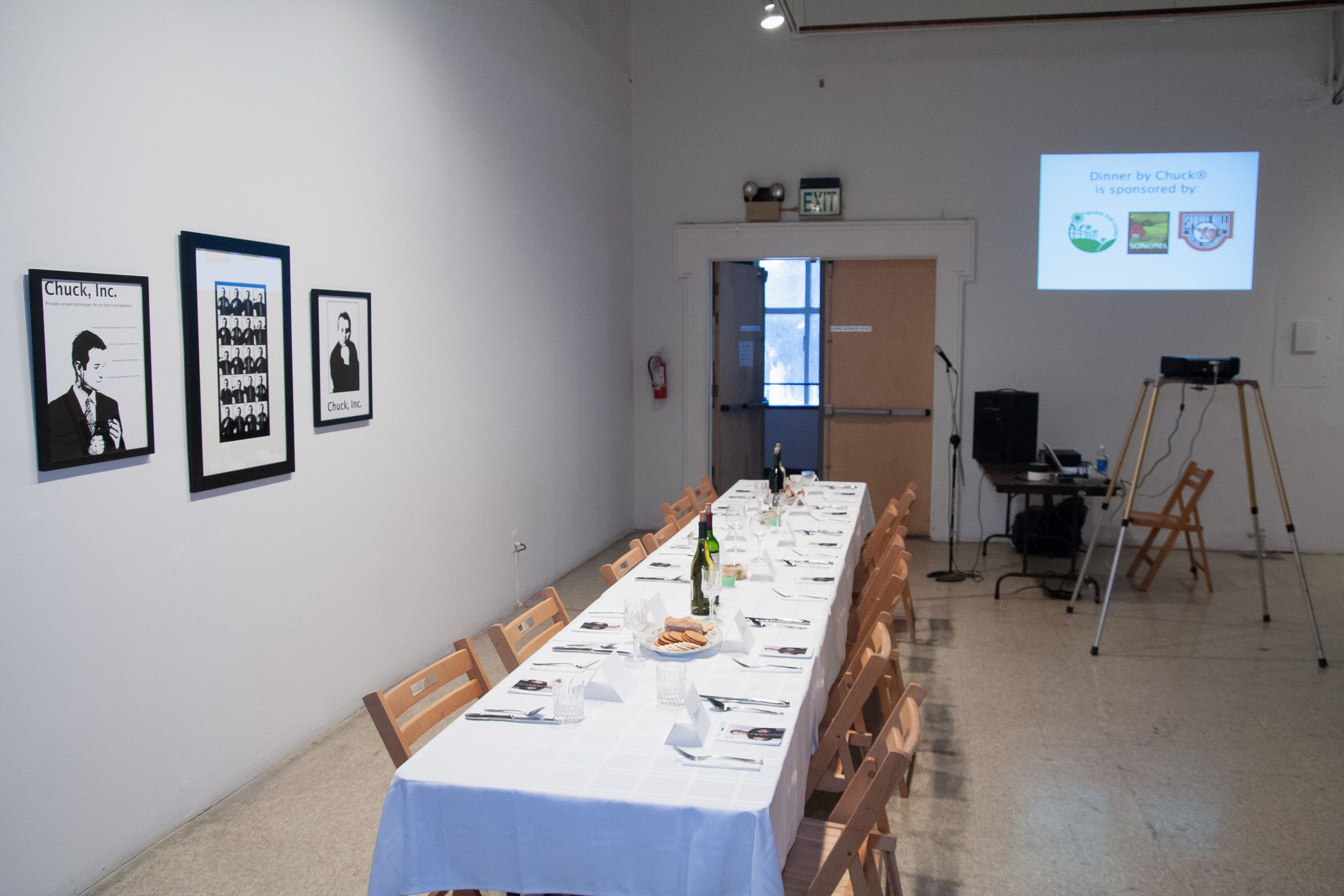 Modern gallery space with dining tables and artwork displayed on walls.