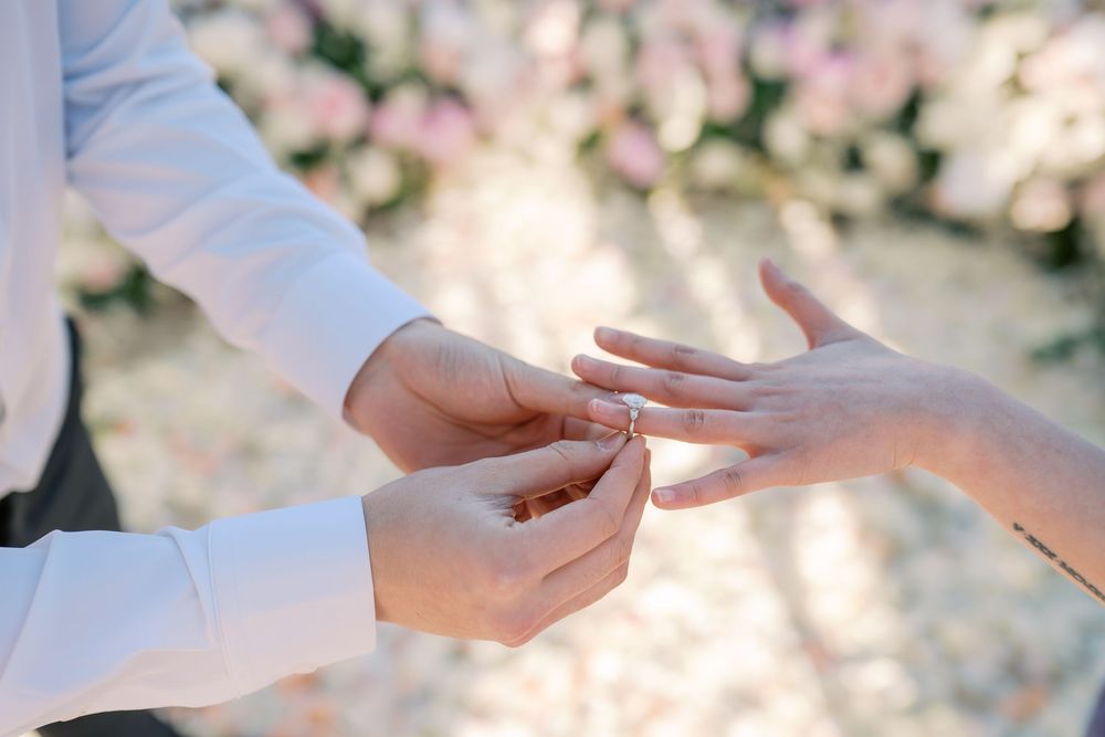 Hands exchanging business cards in a professional setting with soft natural lighting and blurred background.
