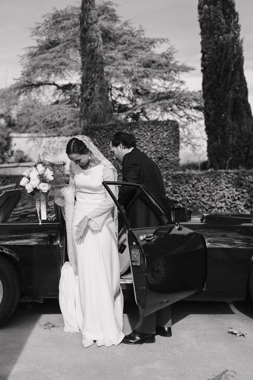 Black and white photo of a couple seated by a piano outdoors  Masia Rosas Sant Cugat.