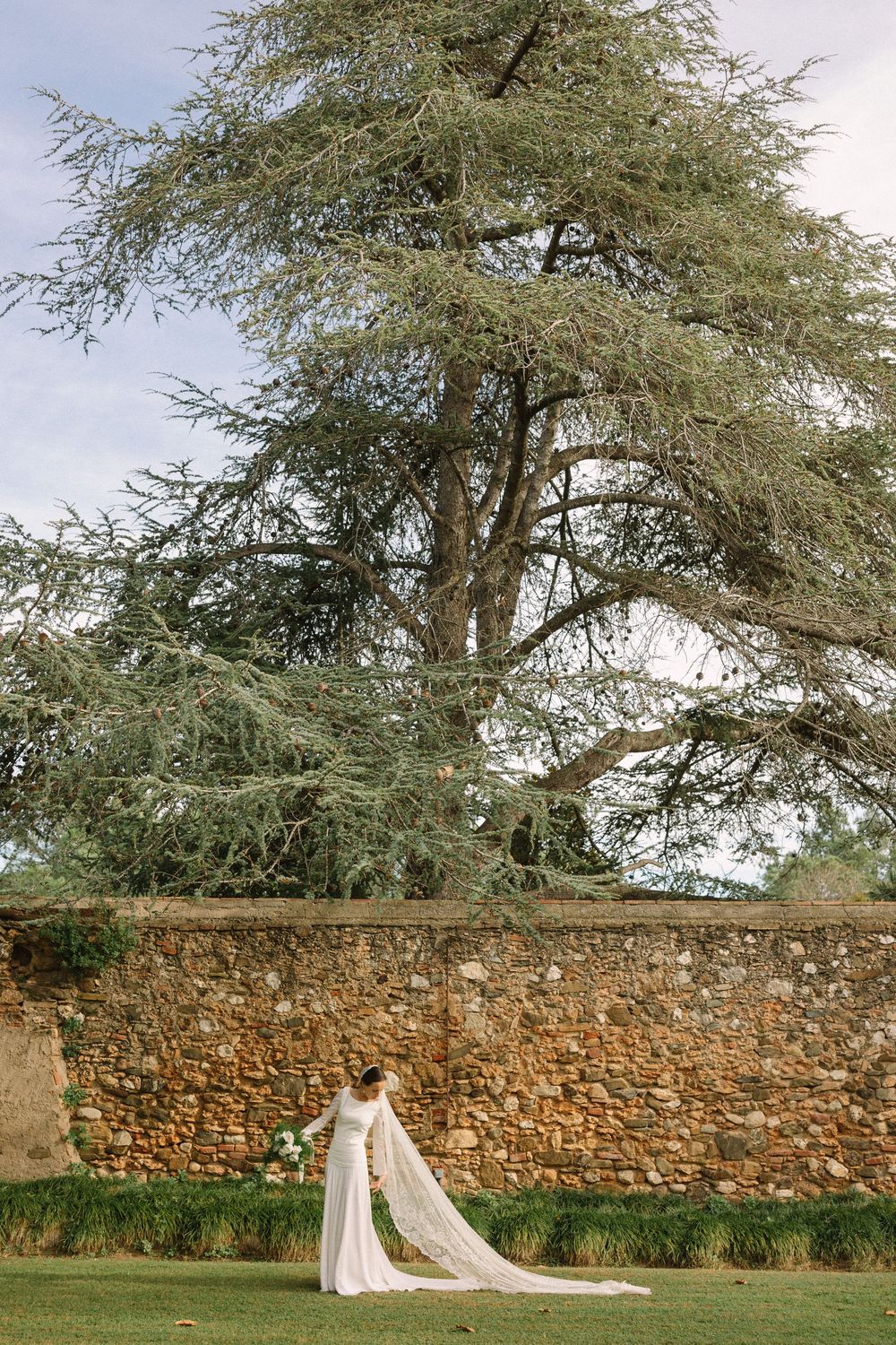 A series of four photos showing a stone wall backdrop with a large tree in a garden setting Masia Rosas Sant Cugat.