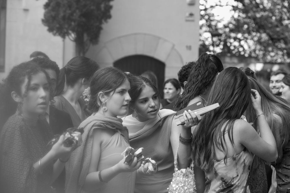 Wedding guests enjoying outdoor celebration in black and white photography.