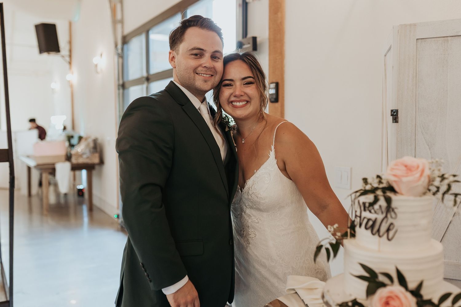 A happy couple shares joyful moments during their wedding reception in an elegant white venue at Canopy Grove by Wedgewood Weddings.