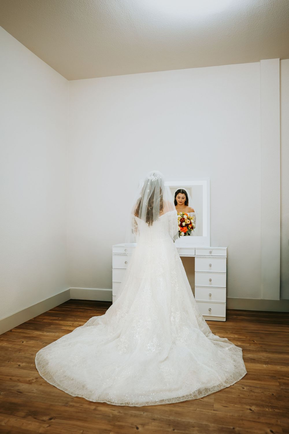 A sequence of bridal preparation photos showing the flowing train of a white wedding dress on hardwood floors.