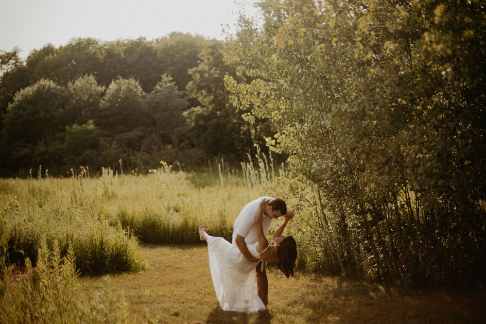 Scenic outdoor wedding venue with golden sunlight streaming through trees.