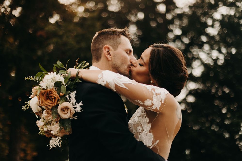 Intimate wedding portraits at golden hour with bokeh lighting effects in the background.