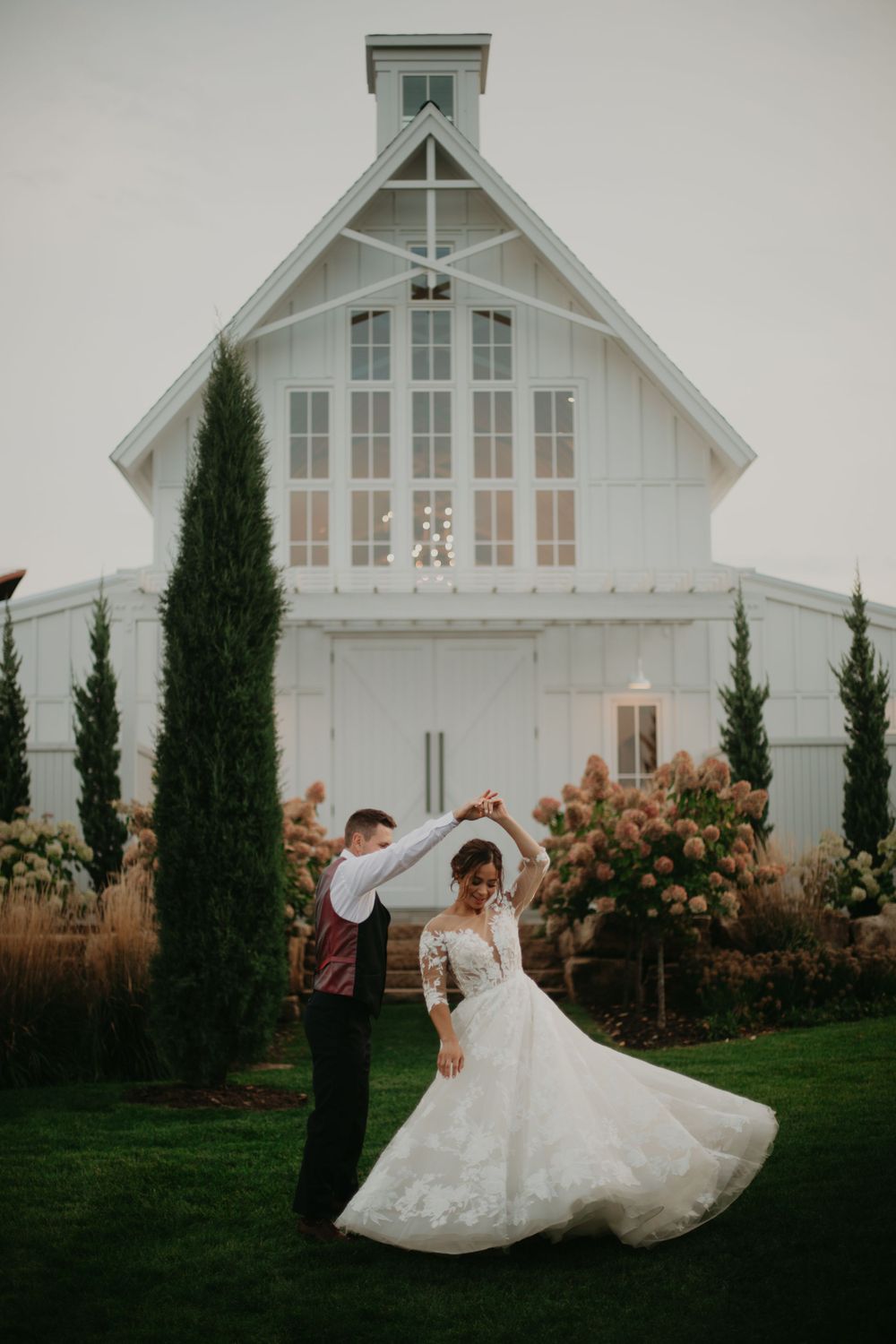 Elegant white chapel wedding venue with cypress trees and flowing bridal gown.