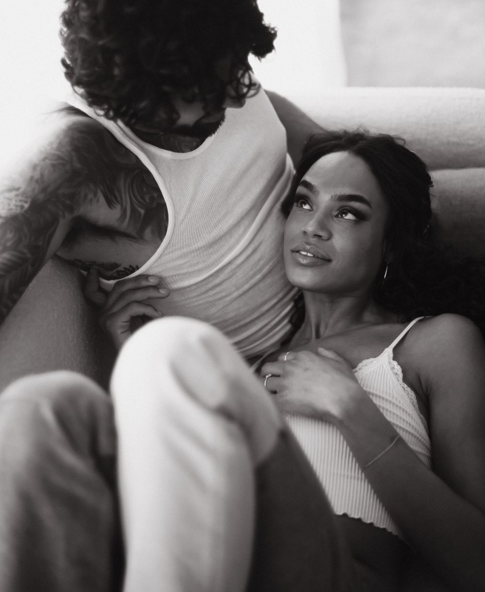 Romantic black and white portrait of a couple lying down in intimate embrace.