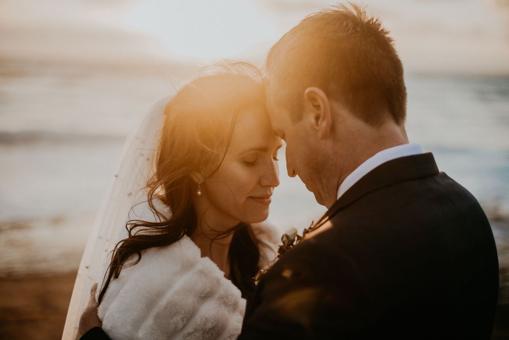 Romantic sunset portraits on a beach with warm golden light.