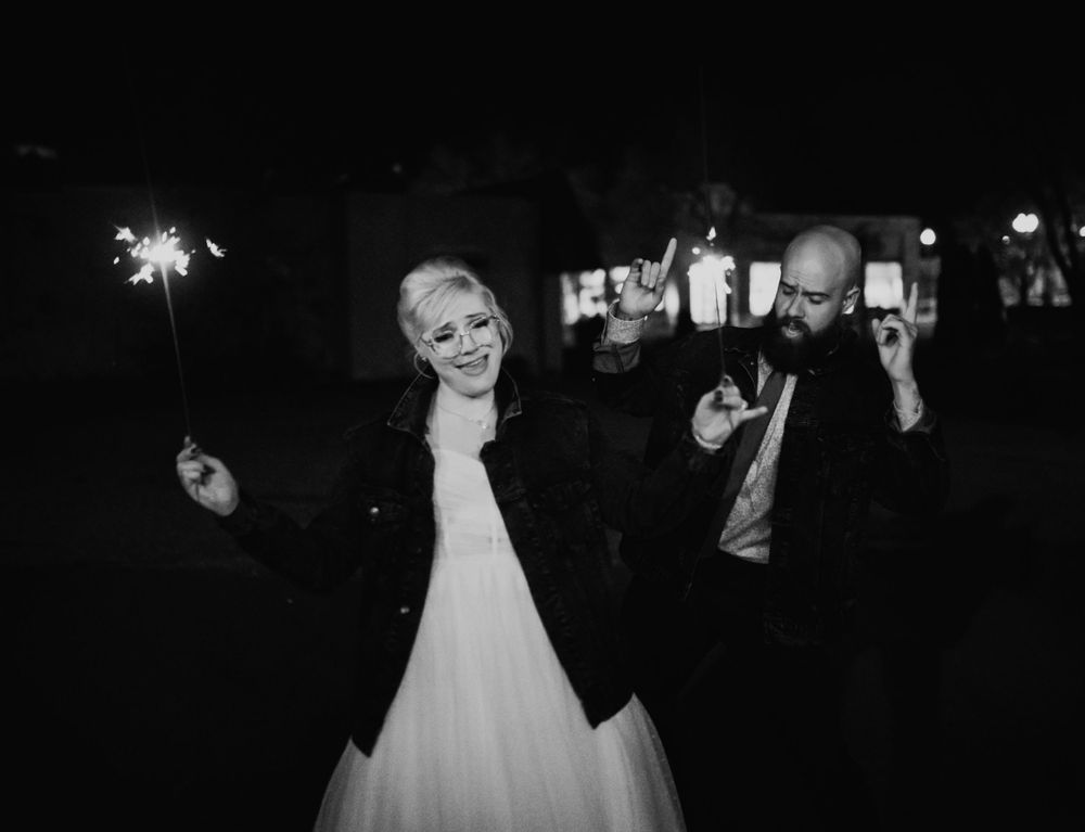 Wedding party dancing under string lights at an outdoor evening celebration.