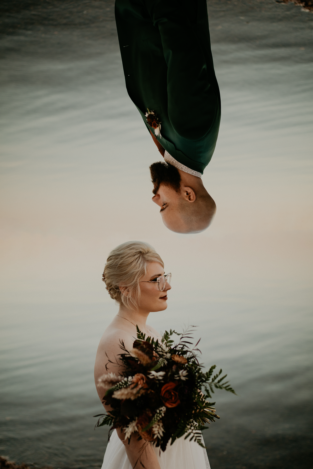Artistic portrait with a bouquet of autumn flowers against a moody background.