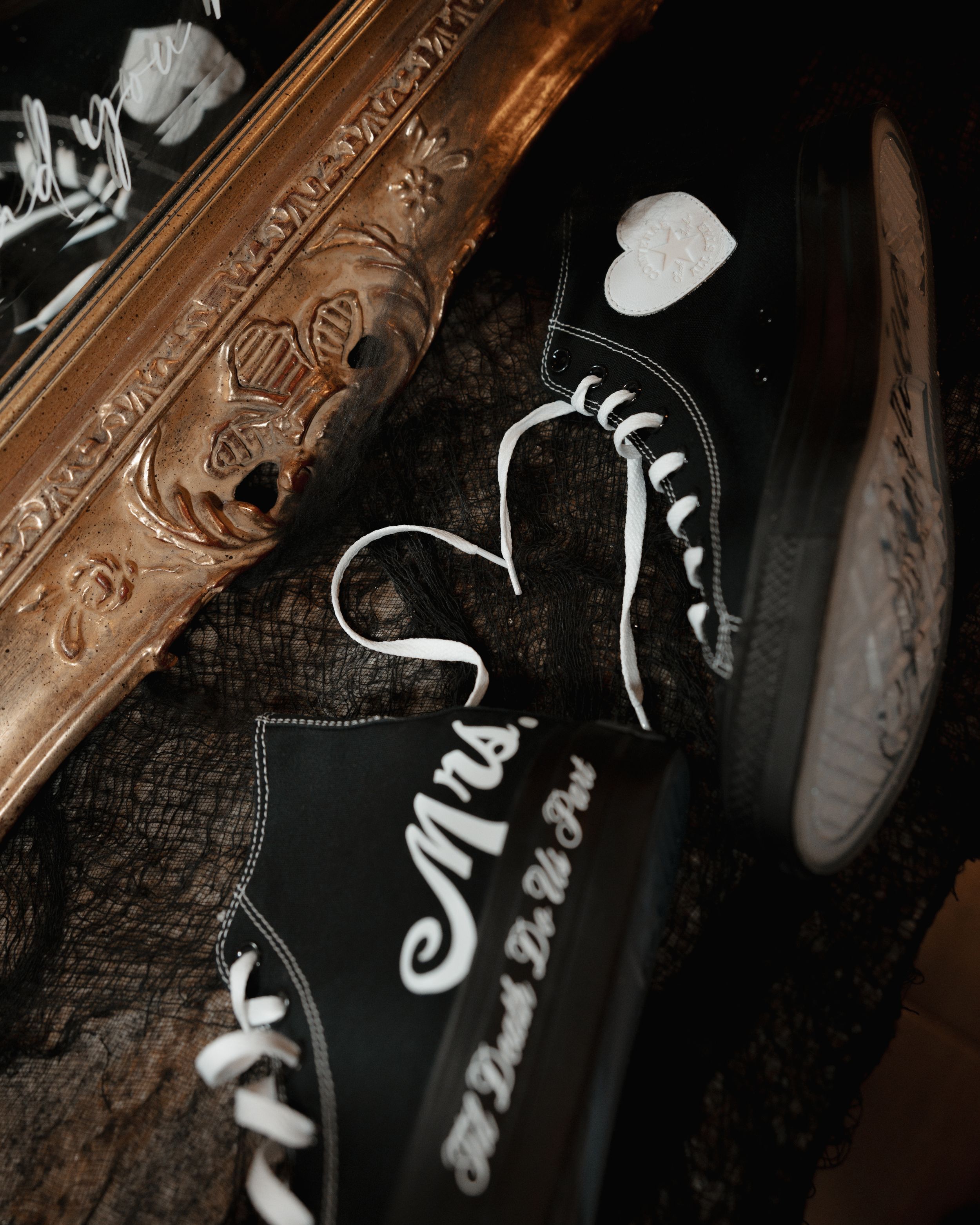 Black and white athletic shoes displayed against a dark background with ornate wooden details.