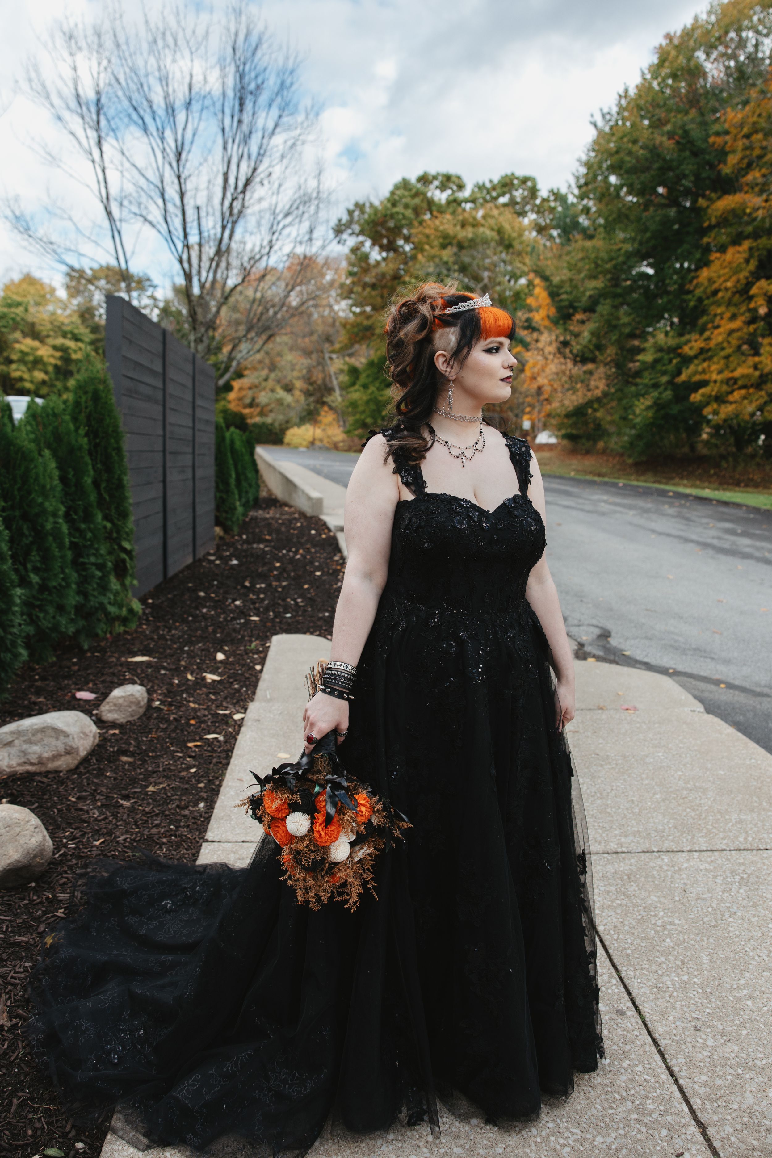 A flowing black tulle gown contrasts beautifully with autumn foliage and a garden path.
