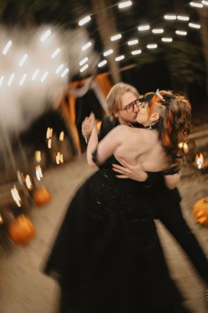 A romantic sequence of black and white photos showing a couple sharing an intimate kiss in a dimly lit venue.