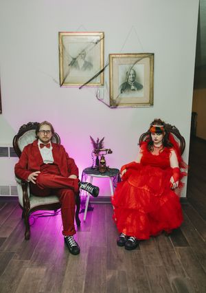 A playful photo series of a couple in red and black attire posing on hardwood floors with pink lighting.