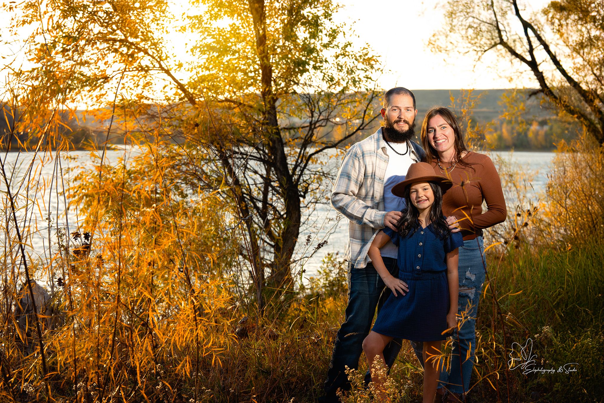 Outdoor family photography session against backdrop of fall foliage and water in Williston, North Dakota.
