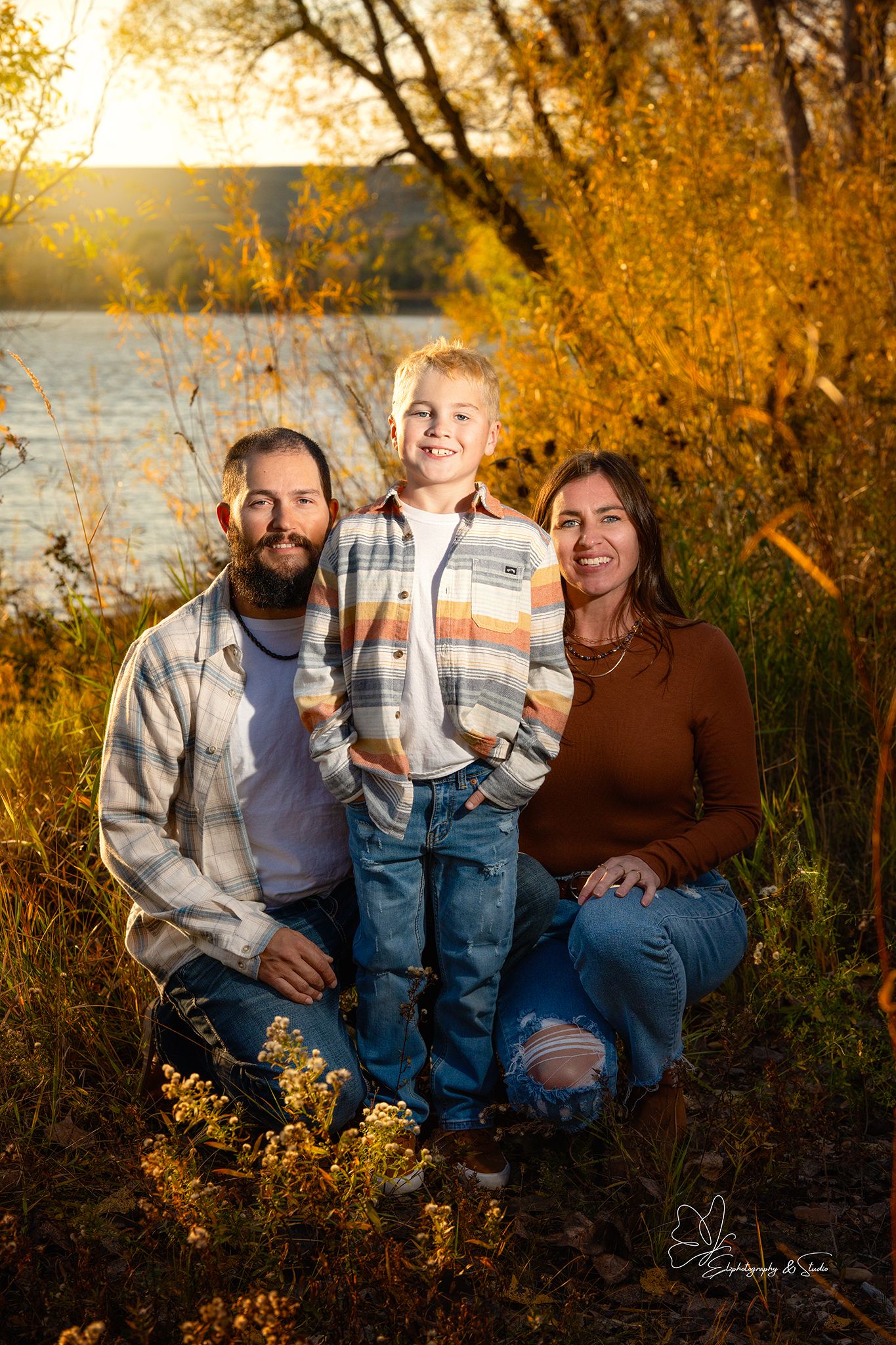 Family sitting together on grass during golden hour autumn photoshoot in Williston, North Dakota.