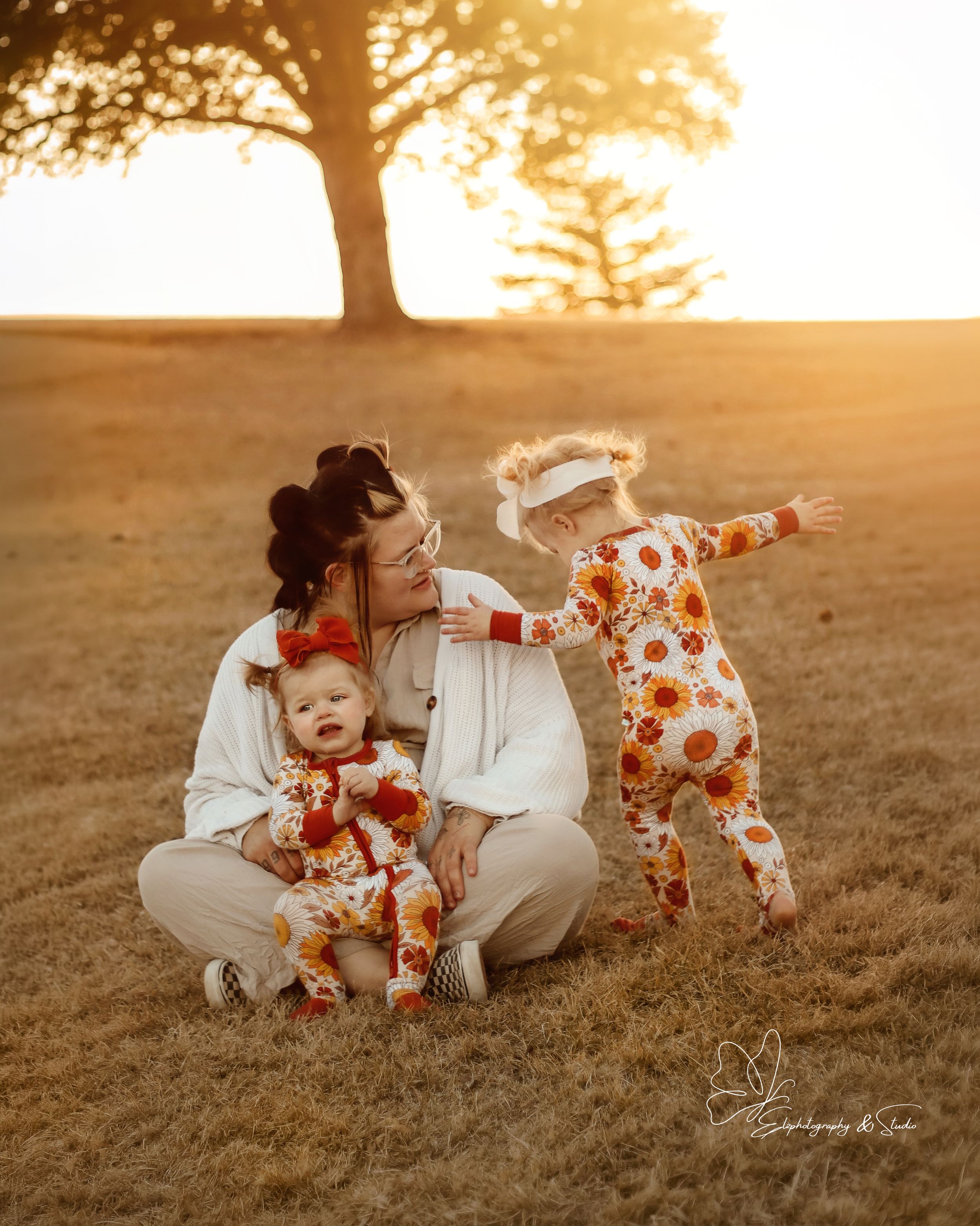 Family moment captured in golden sunset light with matching outfits in Williston, North Dakota.