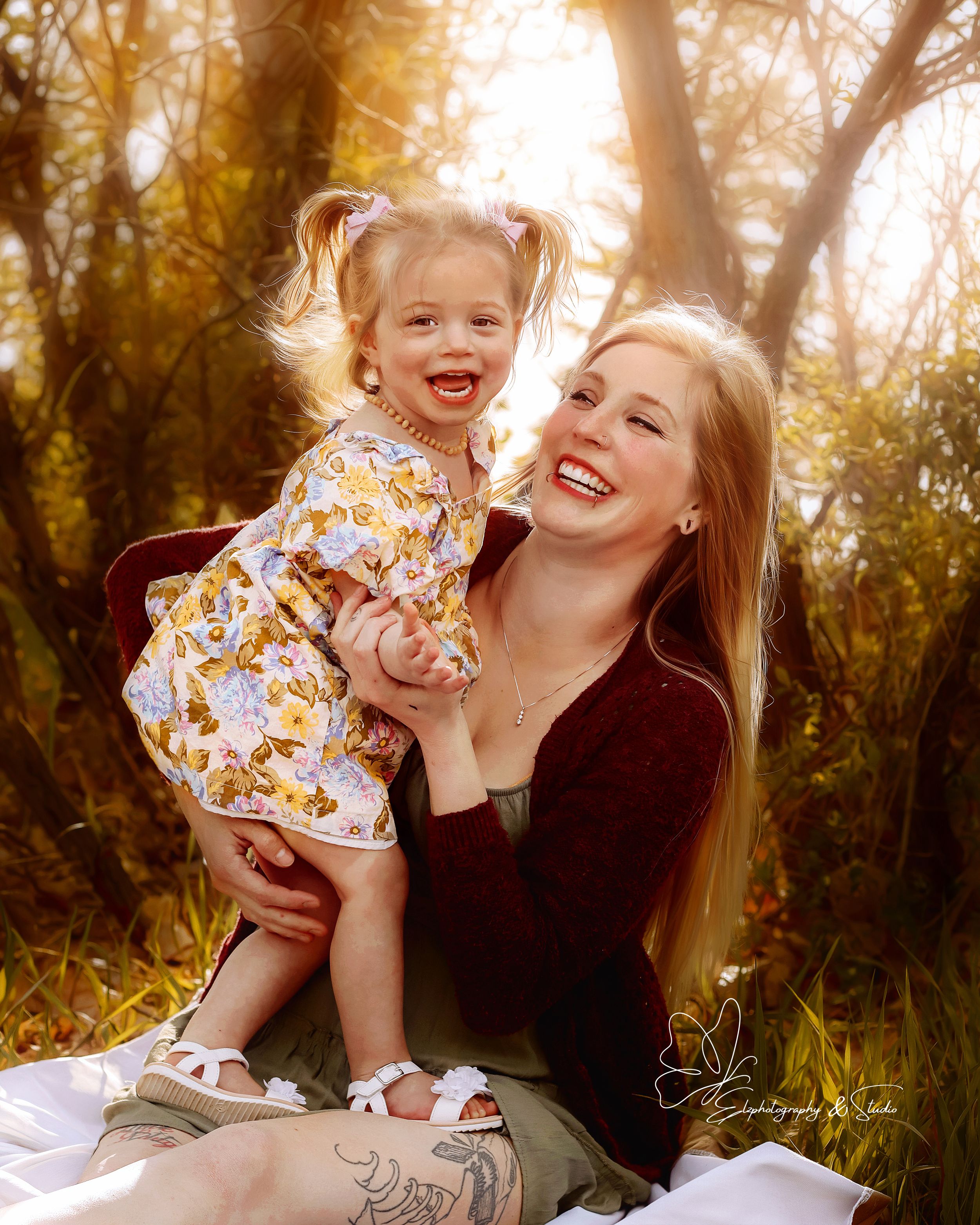 Golden hour photography can be beautiful. Mom and daughter sitting down backlit by sun in Williston, North Dakota.
