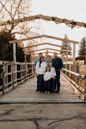 A group poses for photos on a wooden boardwalk during an autumn sunset in Williston, North Dakota.