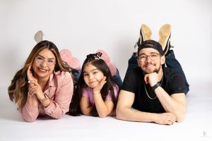 Three people wearing bunny ears pose playfully on a white studio background in Williston, North Dakota.