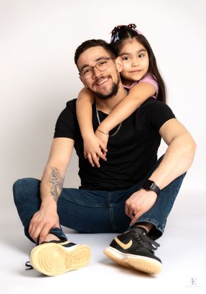 Two people posing together against a white studio background in Williston, North Dakota.