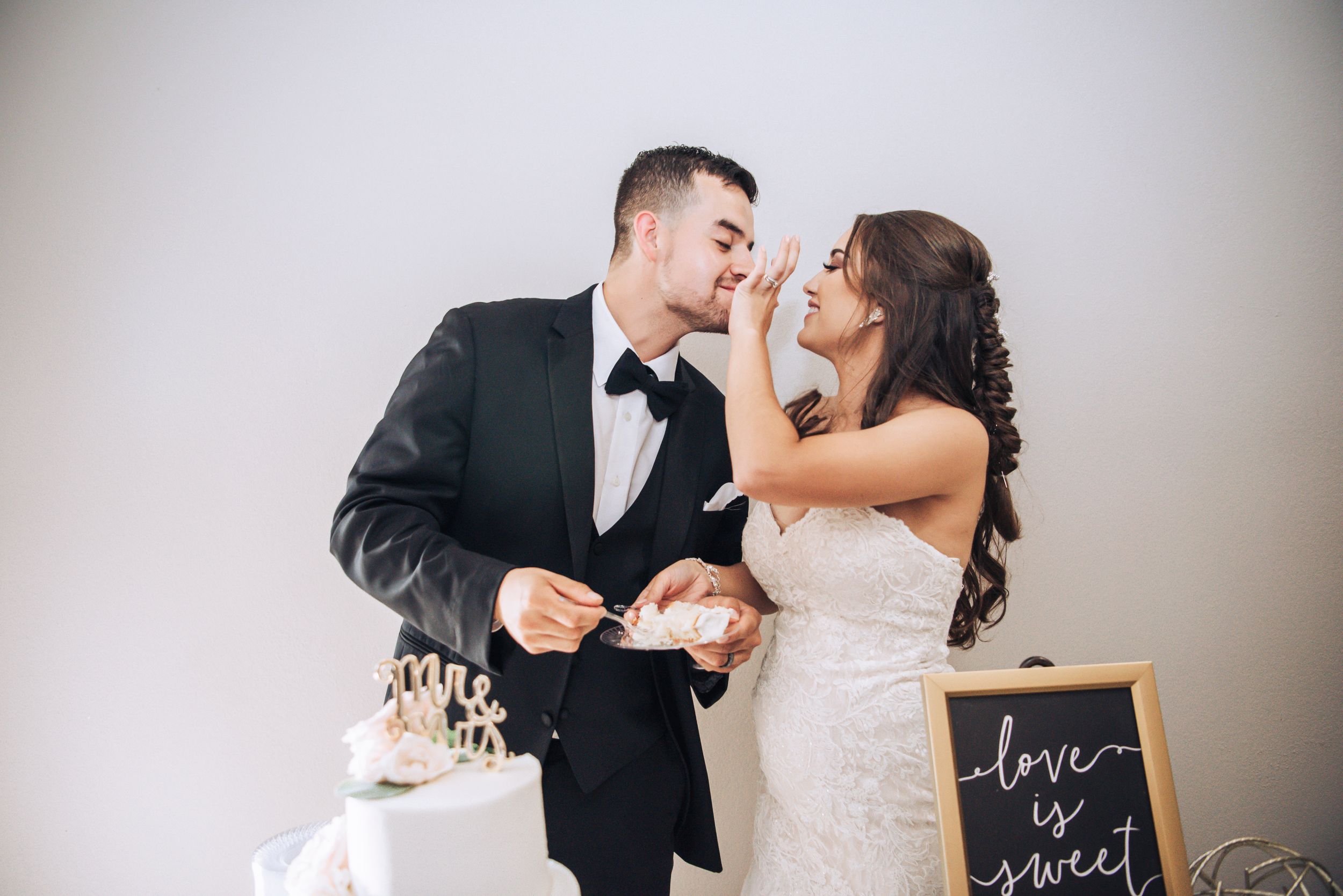Wedding couple sharing intimate moment while cutting cake at reception.