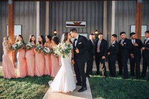 Wedding party lineup outside rustic barn venue.