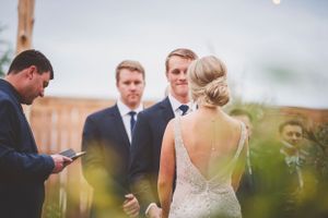Outdoor wedding ceremony with guests gathered under blue skies.