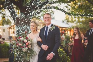Outdoor wedding celebration with string lights and garden decor.
