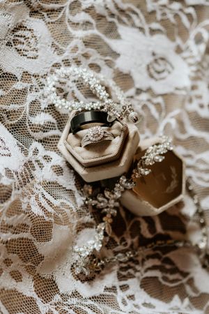Wedding rings and delicate lace details in vintage style close-up shot.