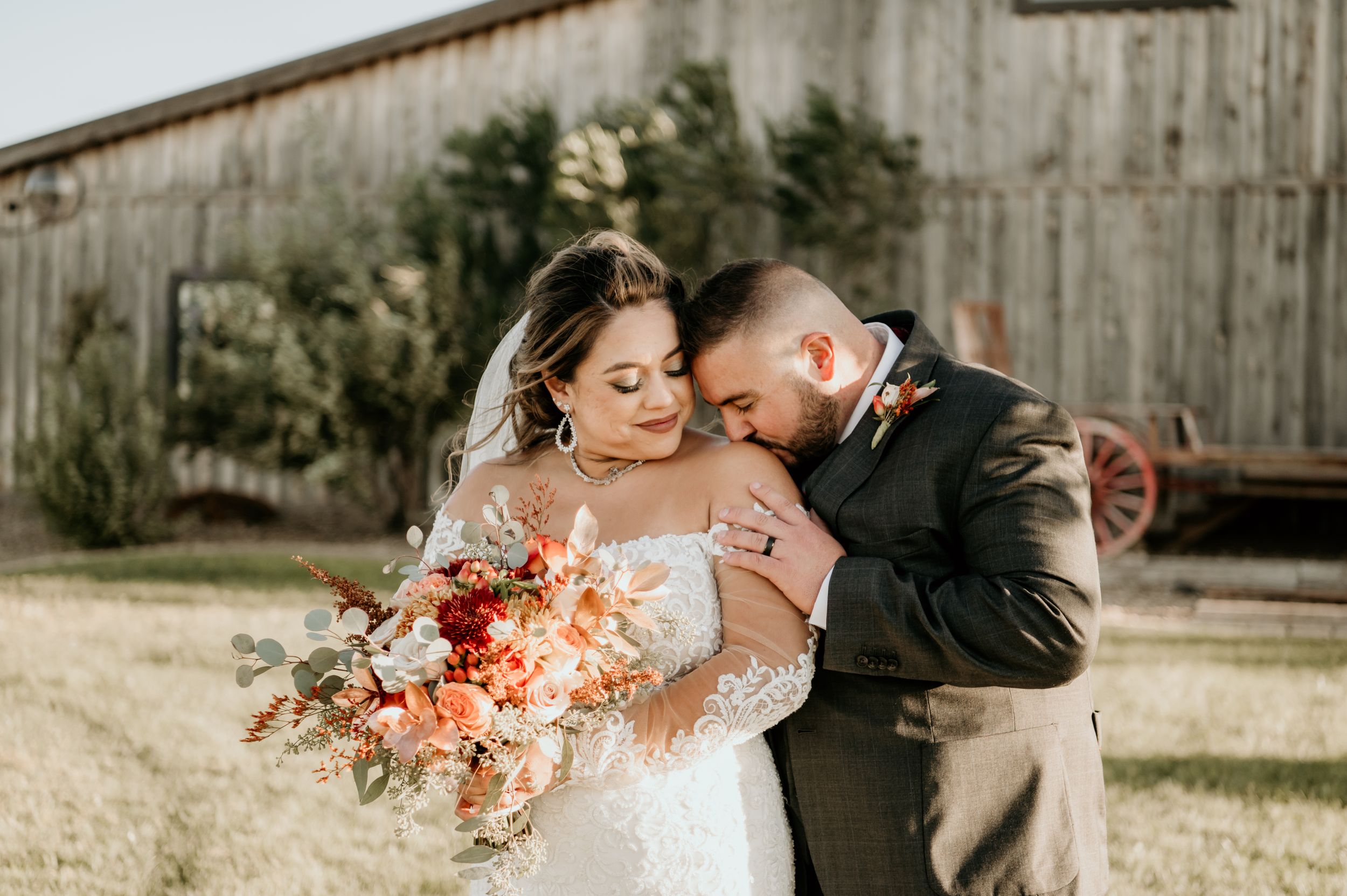 Romantic outdoor wedding portraits against rustic barn backdrop.