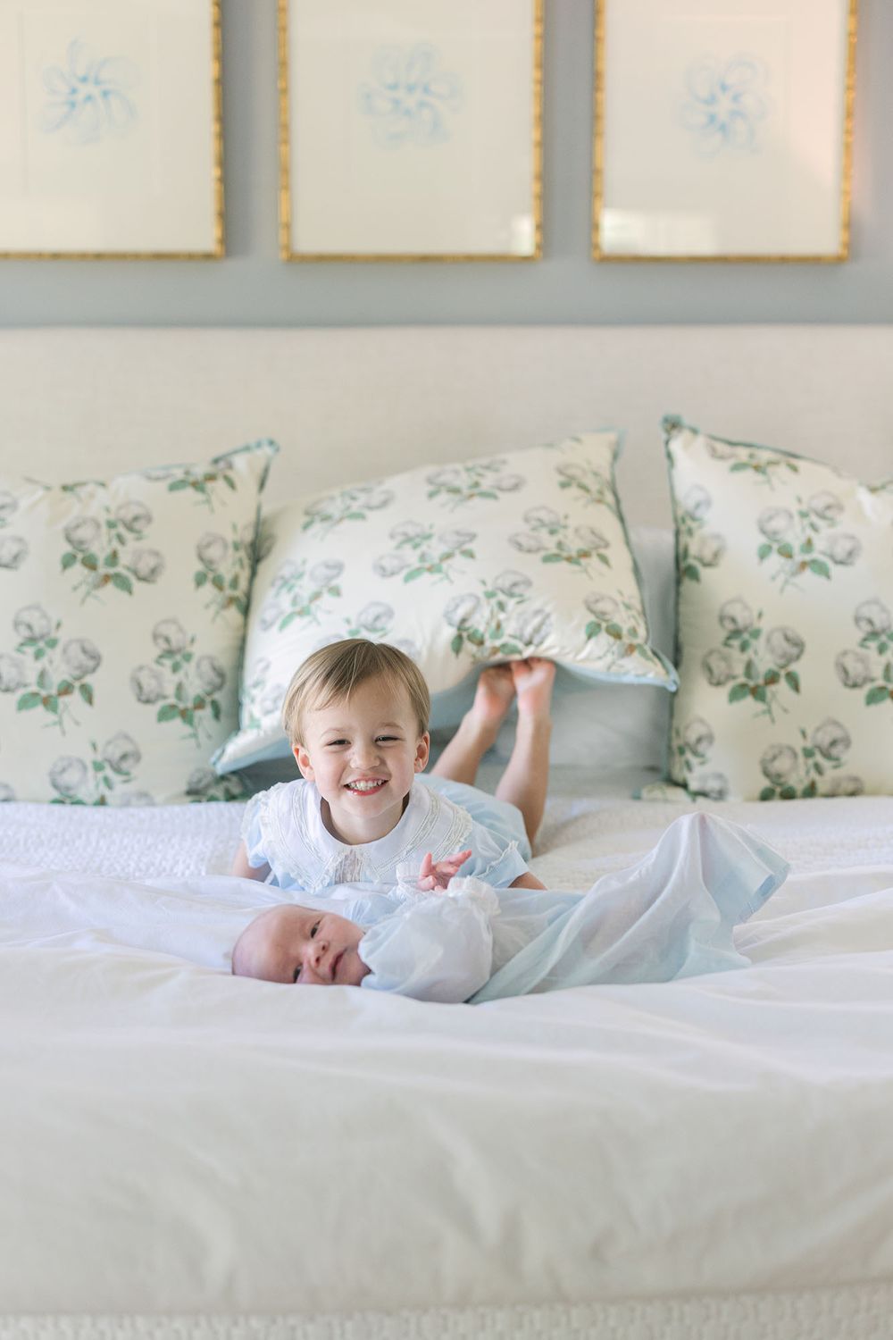 In-home newborn photography of brother smiling over his baby brother by Newborn photographer, Alex Ishee.