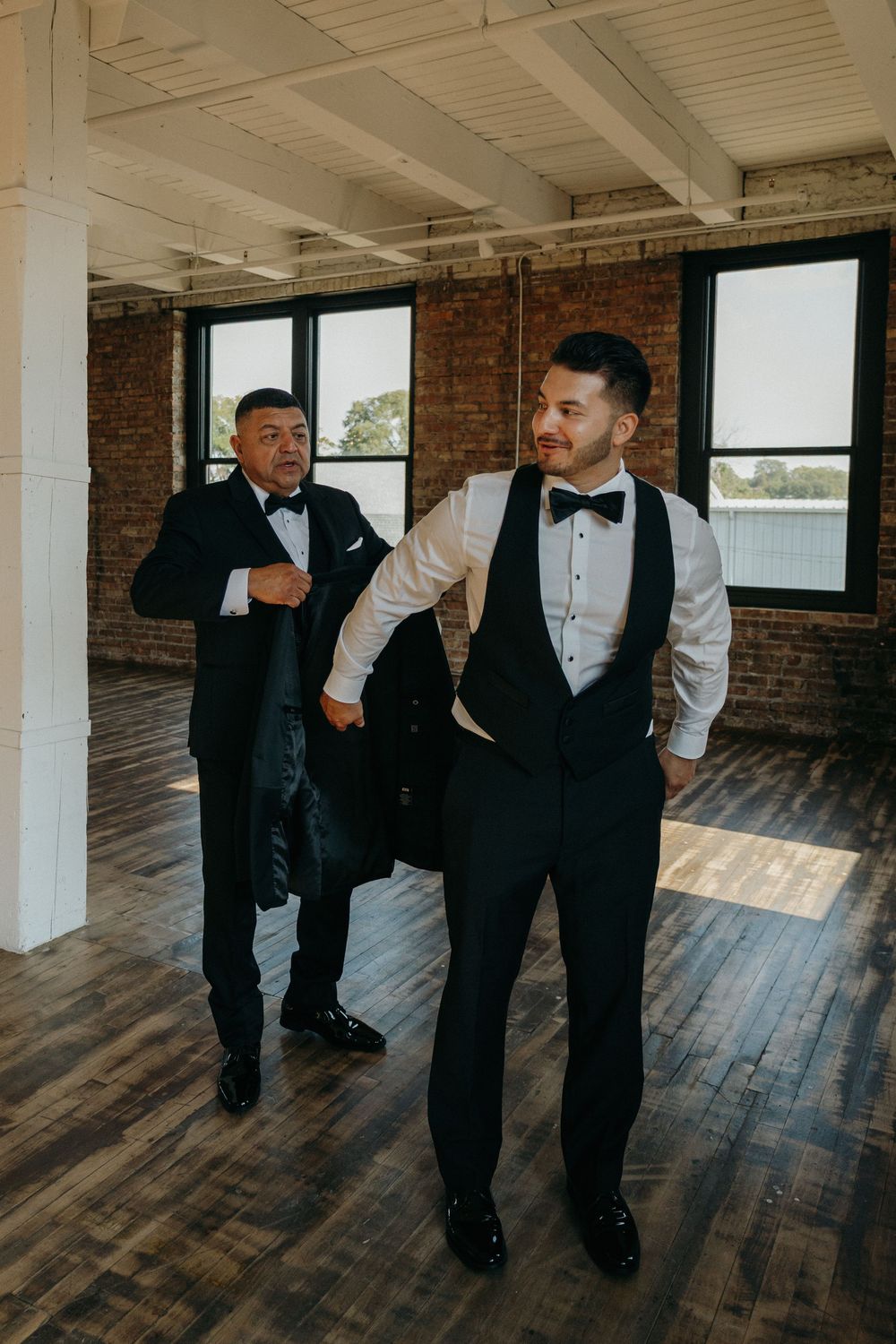 A series of candid moments showing groomsmen in black tuxedos and bow ties walking on rustic hardwood floors.