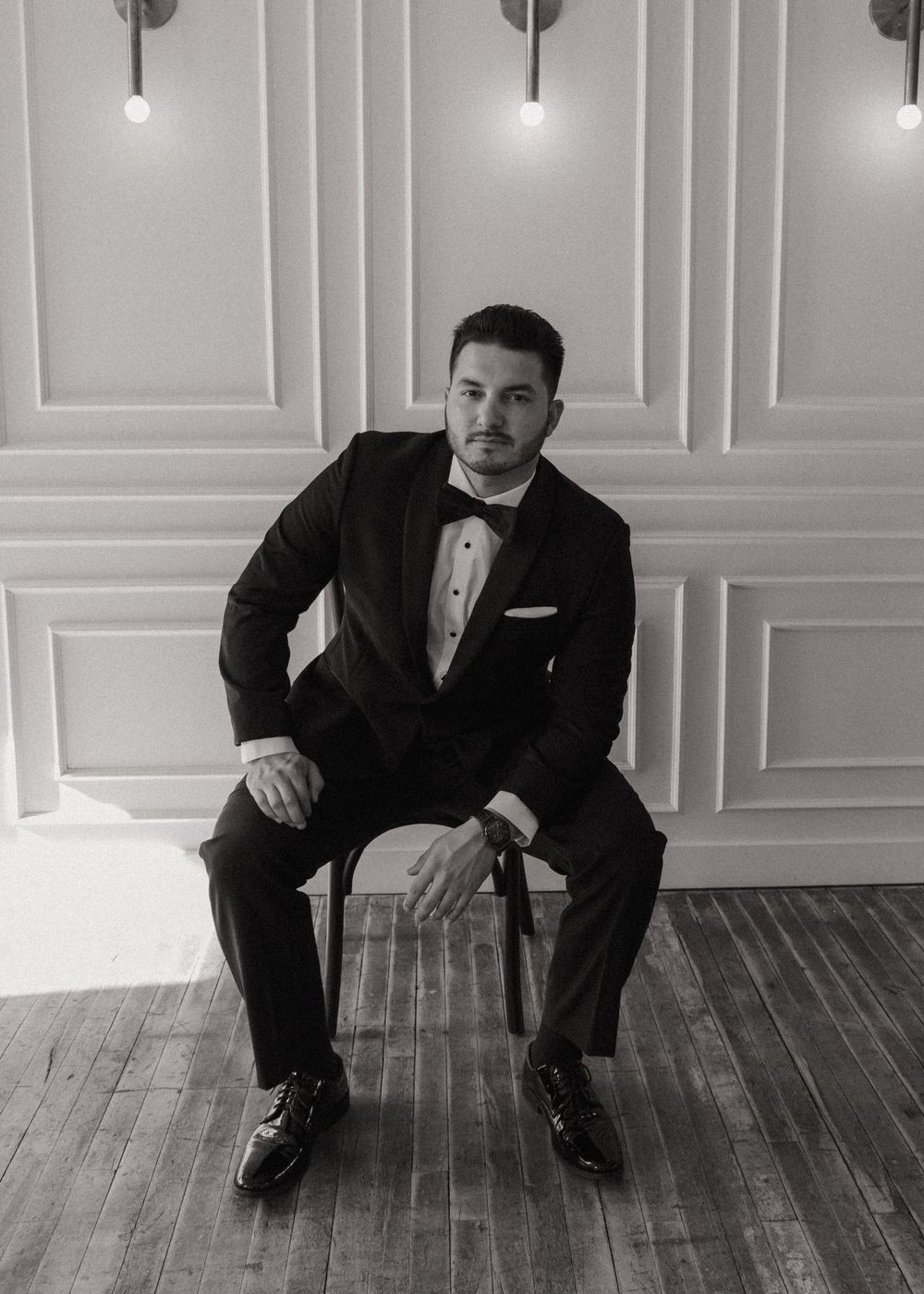 A sequence of black and white photos showing a man in a suit sitting on wooden floor panels.