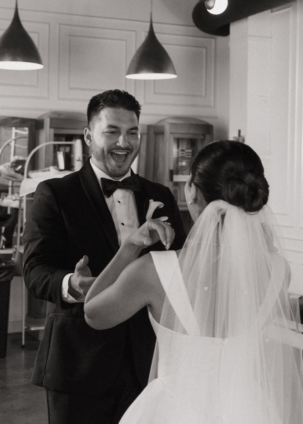A series of black and white wedding photos showing joyful moments between newlyweds during their first look.