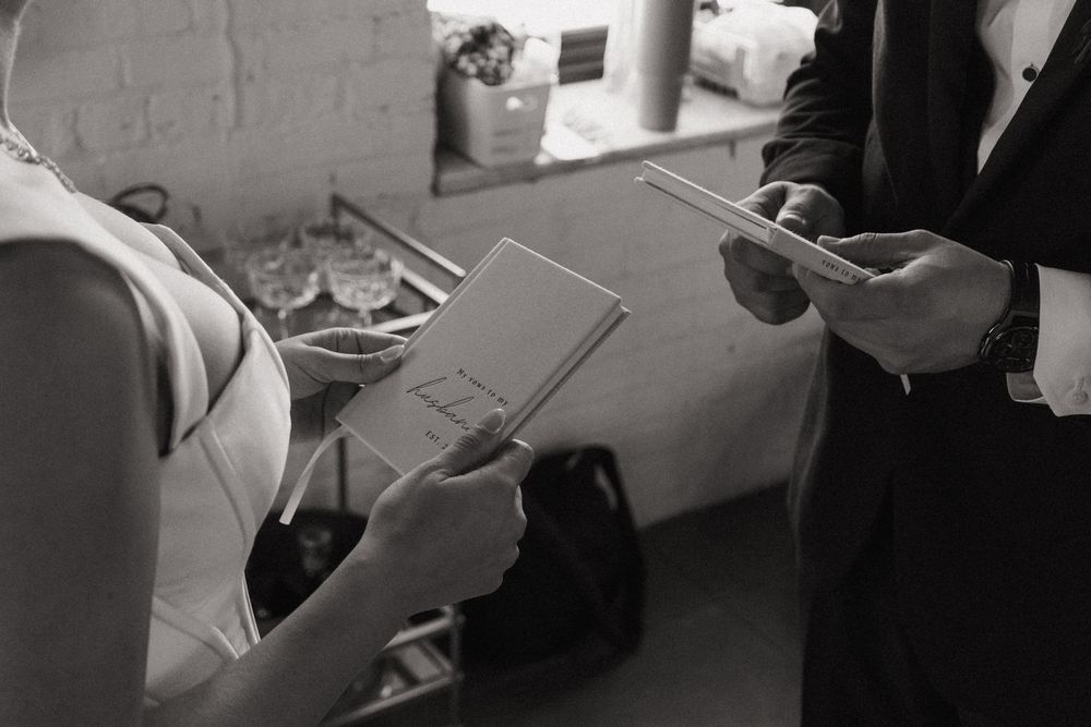 Close-up of hands holding papers during a wedding ceremony preparation.