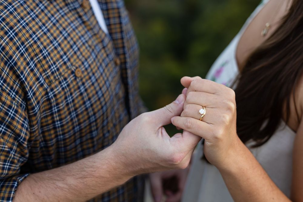 Close-up view of hands adjusting a plaid bowtie on formal attire.