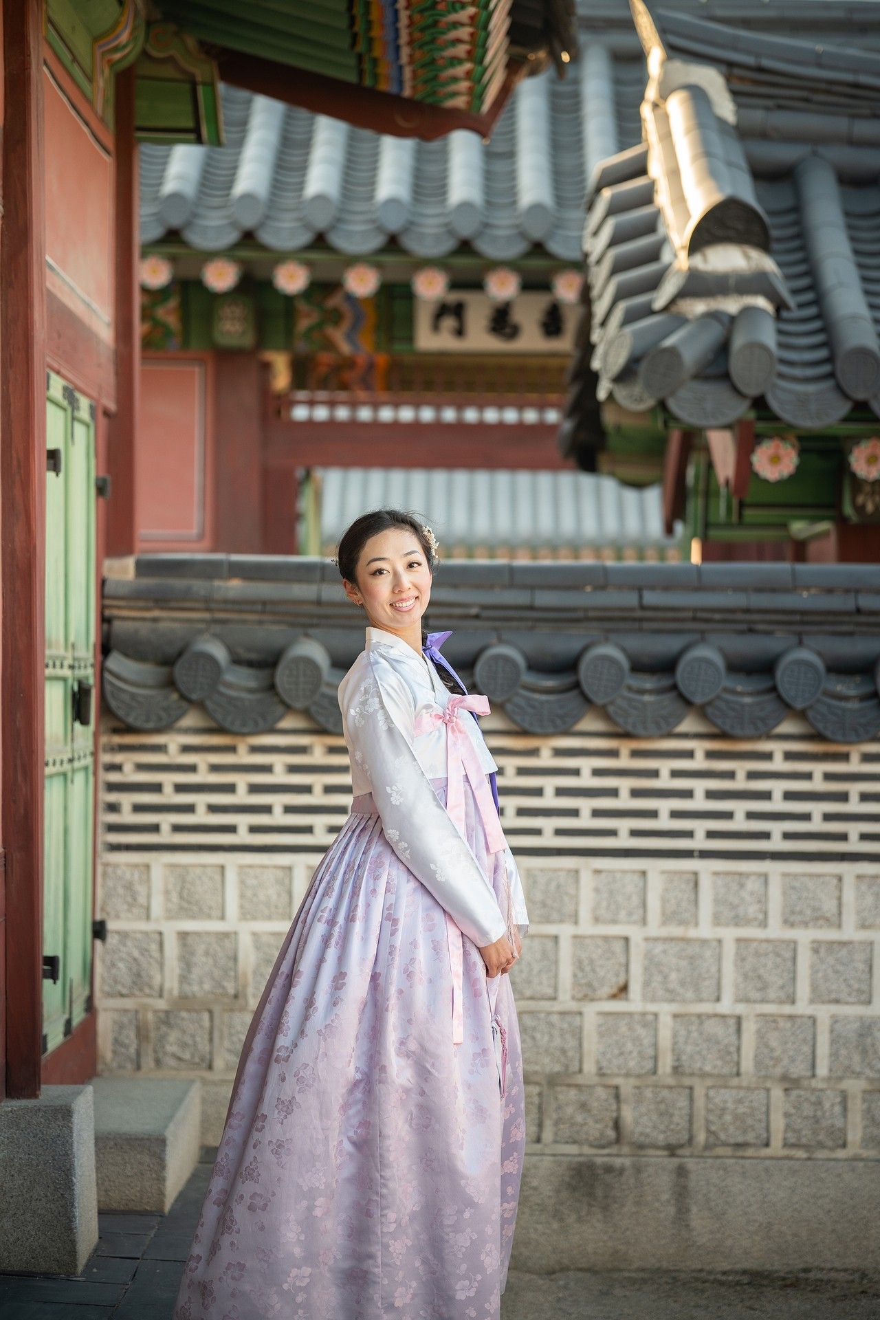 Three sequential photos of someone wearing a traditional Korean hanbok dress posing at a historic temple courtyard.