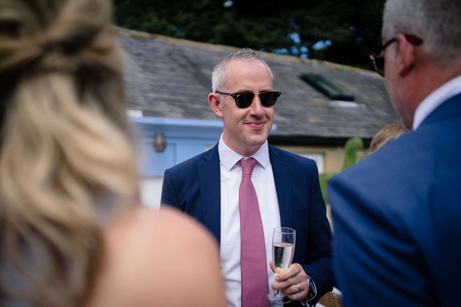 Wedding guests mingling and socializing during outdoor reception. Woodhill Hall.